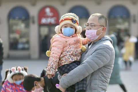 Bé gái và bố đeo khẩu trang tại nhà ga Bắc Kinh ngày 21/1/2020. (Nguồn: Chinadaily)