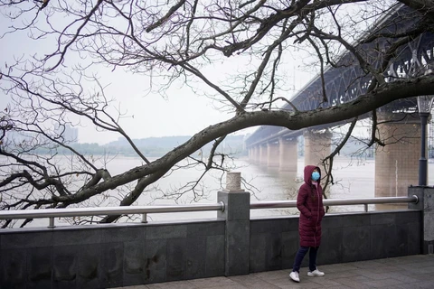 Một người phụ nữ đi bộ dưới cầu bên sông Dương Tử ở Vũ Hán. (Nguồn: Reuters)