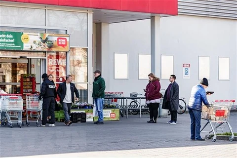 Người dân xếp hàng bên ngoài siêu thị ở Berlin, Đức ngày 23/3/2020, trong bối cảnh dịch COVID-19 lan rộng. (Nguồn: THX/TTXVN) 