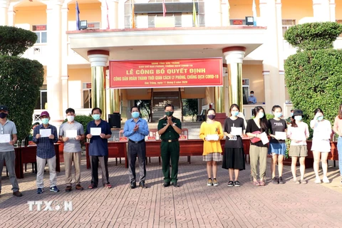 Lãnh đạo Ủy ban Nhân dân tỉnh và Bộ Chỉ huy Quân sự tỉnh Sóc Trăng trao giấy chứng nhận hoàn thành cách ly cho các công dân. (Ảnh : Trung Hiếu/TTXVN)