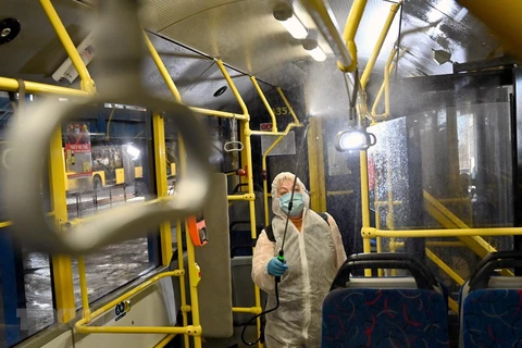 Nhân viên phun thuốc khử trùng trên xe điện nhằm ngăn chặn lây lan của COVID-19 tại Kiev, Ukraine. (Ảnh: AFP/TTXVN) 