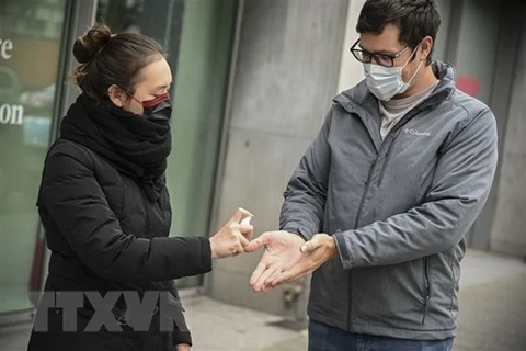 Người dân đeo khẩu trang và khử khuẩn để phòng dịch COVID-19 tại Brussels, Bỉ. (Nguồn: THX/TTXVN)