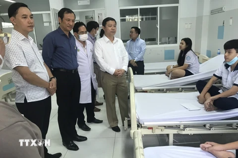 Phó Chủ tịch Ủy ban Nhân dân Thành phố Hồ Chí Minh Dương Anh Đức (đứng giữa) thăm các em học sinh bị nạn. (Ảnh: Hồng Giang/TTXVN)