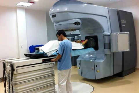 Nhân viên y tế vận hành máy xạ trị gia tốc tuyến tính hiện đại nhất Việt Nam Varian Clinac iX để điều trị cho bệnh nhân. (Ảnh: T.G/Vietnam+)