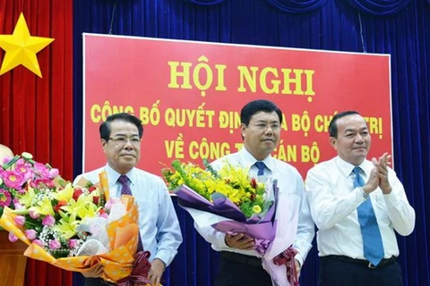 Đại diện lãnh đạo Tỉnh ủy Cà Mau tặng hoa chúc mừng tân Bí thư Tỉnh ủy Nguyễn Tiến Hải (giữa) và nguyên Bí thư Tỉnh ủy Dương Thanh Bình (bên trái) nhận nhiệm vụ mới. (Ảnh: Huỳnh Thế Anh/TTXVN) 