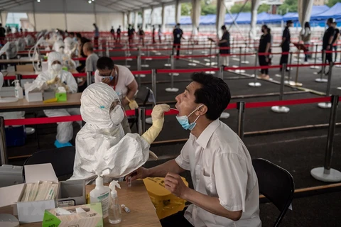 Nhân viên y tế lấy mẫu dịch xét nghiệm COVID-19 cho người dân tại Bắc Kinh, Trung Quốc, ngày 24/6/2020. (Nguồn: AFP/TTXVN)