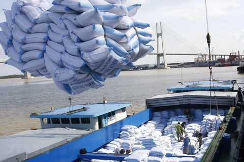 Bốc xếp gạo xuất khẩu sang tại cảng Sài Gòn. (Nguồn: TTXVN)