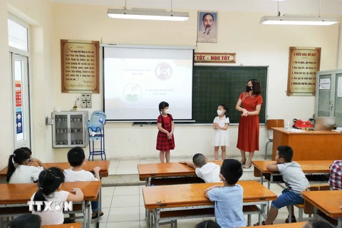 Học sinh lớp 1 trường Tiểu học Thịnh Liệt, quận Hoàng Mai (Hà Nội) được phổ biến, tuyên truyền, hướng dẫn phòng chống dịch cơ bản trong ngày đầu tới trường. (Ảnh: Thanh Tùng/TTXVN) 