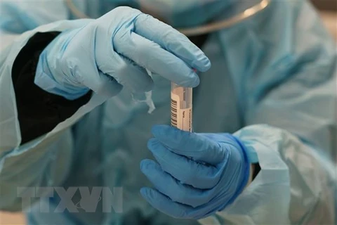 Nhân viên y tế lấy mẫu xét nghiệm COVID-19. (Ảnh: AFP/TTXVN)