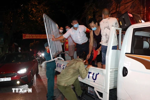 Lực lượng chức năng tháo dỡ hàng rào cách ly ở khu phố Nguyễn Chí Thanh, thành phố Hải Dương. (Ảnh: Mạnh Tú/TTXVN)