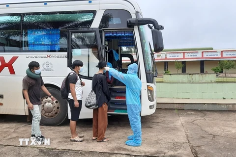 Tiếp nhận và kiểm tra thân nhiệt cho các lưu học sinh Lào tại cửa khẩu quốc tế Bờ Y, tỉnh Kon Tum ngày 16/10 để đưa về cách ly 14 tại Khánh Hòa. (Ảnh: TTXVN phát)