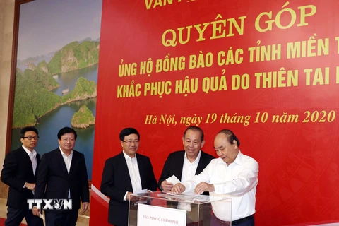 Thủ tướng Nguyễn Xuân Phúc và các Phó Thủ tướng ủng hộ đồng bào niền Trung khắc phục hậu quả do do thiên tai lũ lụt. (Ảnh: Thống Nhất/TTXVN)