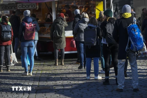 Người dân xếp hàng bên ngoài siêu thị ở Muenster, miền Tây Đức trong bối cảnh nhà chức trách yêu cầu thực hiện giãn cách xã hội nhằm ngăn dịch COVID-19 lây lan. (Nguồn: AFP/TTXVN)