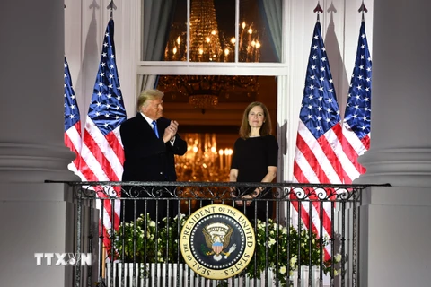 Tổng thống Mỹ Donald Trump (trái) chúc mừng bà Amy Coney Barrett (phải) sau lễ tuyên thệ nhậm chức Thẩm phán Tòa án Tối cao tại Washington, DC ngày 26/10/2020. (Ảnh: AFP/TTXVN)