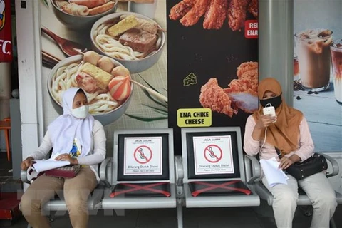 Người dân đeo khẩu trang và thực hiện giãn cách xã hội phòng lây nhiễm COVID-19 tại Jakarta, Indonesia. (Ảnh: THX/TTXVN) 