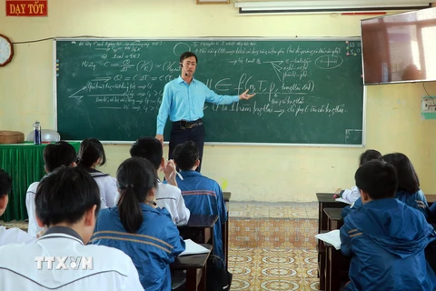 Thầy Vũ Văn Hợp hướng dẫn học sinh ôn luyện môn Hóa học. (Ảnh: Nguyễn Lành/TTXVN)