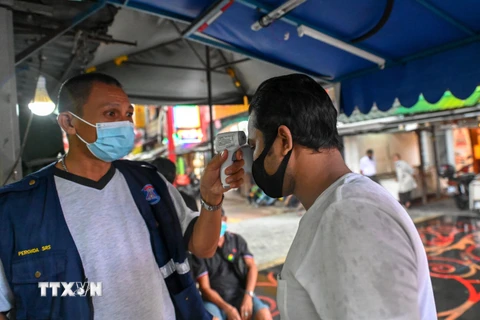 Kiểm tra thân nhiệt phòng lây nhiễm COVID-19 tại Kuala Lumpur, Malaysia ngày 23/11/2020. (Ảnh: THX/TTXVN)