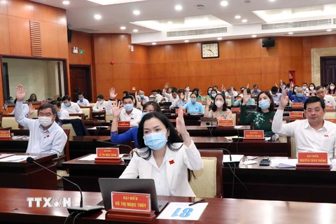 Các đại biểu Hội đồng nhân dân Thành phố Hồ Chí Minh biểu quyết thông qua Dự thảo Nghị quyết. (Ảnh: Xuân Khu/TTXVN)