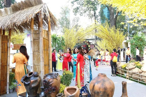 Các bạn trẻ chụp ảnh tại Lễ hội Tết Việt với nét mộc mạc của làng quê, hay một góc Sài Gòn xưa. Ảnh minh họa. (Ảnh: Thanh Vũ /TTXVN