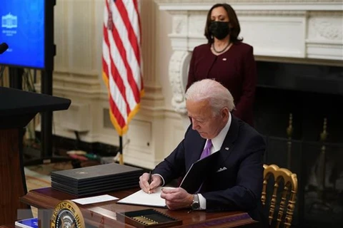 Tổng thống Mỹ Joe Biden ký một sắc lệnh tại Nhà Trắng ở Washington, DC, ngày 21/1/2021. (Ảnh: AFP/TTXVN)
