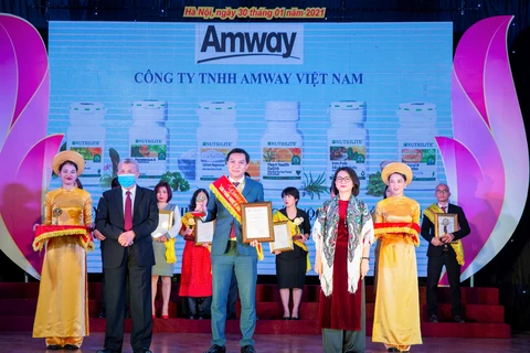 Đại diện Amway Việt Nam nhận Bằng khen và kỷ niệm chương từ bà Trần Việt Nga - Phó Cục trưởng Cục An toàn thực phẩm và ông Trần Đáng - Chủ tịch Hiệp hội TPC. (Nguồn: Vietnam+)