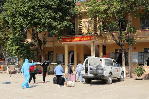 Lực lượng chức năng huyện Mường Ảng, tỉnh Điện Biên đưa các trường hợp cách ly đến khu cách ly tập trung. (Ảnh: Xuân Tiến/TTXVN)