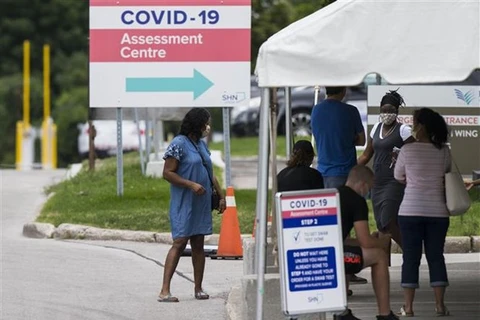 Người dân chờ xét nghiệm COVID-19 tại Toronto, Canada. (Ảnh: THX/TTXVN)