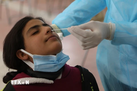 Nhân viên y tế lấy mẫu xét nghiệm COVID-19 cho người dân tại Hebron, Palestine ngày 27/2/2021. (Ảnh: THX/TTXVN)