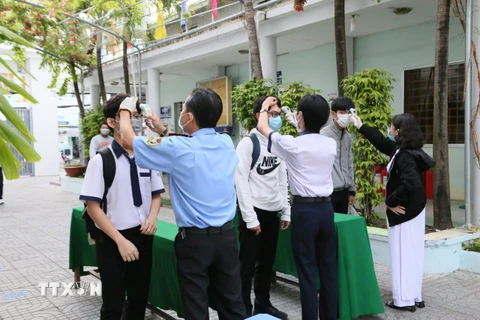 Đo thân nhiệt trước khi vào lớp tại trường THPT Phan Ngọc Hiển, thành phố Cần Thơ. (Ảnh: Ánh Tuyết/TTXVN)
