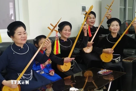 Nghệ sỹ ưu tú Hoàng Kim Tuế (ngoài cùng bên trái) trong một buổi tập hát then đàn tính cùng các nghệ sỹ tỉnh Cao Bằng. (Ảnh: TTXVN phát)