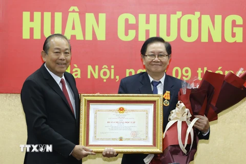 Phó Thủ tướng Thường trực Trương Hòa Bình trao tặng Huân chương Độc lập hạng Nhì cho Nguyên Bộ trưởng Bộ Nội vụ Lê Vĩnh Tân. (Ảnh: Văn Điệp/TTXVN)