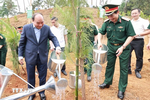 Chủ tịch nước Nguyễn Xuân Phúc cùng các đại biểu trồng cây tại Khu Di tích K9. (Ảnh: Thống Nhất/TTXVN)