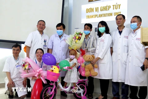 Ban Giám đốc Bệnh viện Trung ương Huế tặng hoa cho bệnh nhi Hồ Thị Tr.. (Ảnh: Tường Vi/TTXVN)
