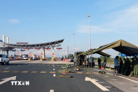 Ban chỉ huy Quân sự thị xã Quảng Yên đang dựng trạm kiểm soát lưu động tại chân cầu Bạch Đằng, trên cao tốc Quảng Ninh với Hải Phòng. (Ảnh: Văn Đức/TTXVN)