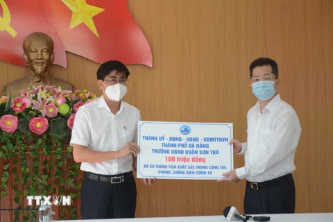 Bí thư Thành ủy Đà Nẵng Nguyễn Văn Quảng trao số tiền thưởng nóng cho đại diện quận Sơn Trà. (Ảnh: Văn Dũng/TTXVN)
