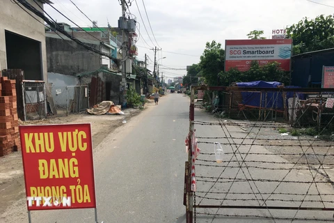 Lực lượng chức năng chốt chặn đầu đường TL19, đoạn giao đường Hà Huy Giáp (phường Thạnh Lộc, Quận 12, Thành phố Hồ Chí Minh). (Ảnh: Tiến Lực/TTXVN) 