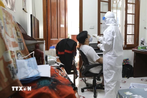 Nhân viên y tế quận Hoàn Kiếm đến lấy mẫu tại hộ gia đình có người tự cách ly liên quan đến trường hợp mắc COVID-19 (ảnh chụp 31/5/2021). (Ảnh: Minh Quyết/TTXVN) 
