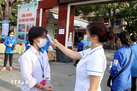 Kiểm tra thân nhiệt cho thí sinh tại các địa điểm thi ở Hà Tĩnh. (Ảnh: Công Tường/TTXVN)