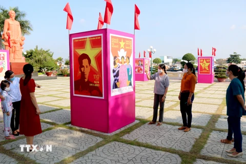 Người dân xem triển lãm tranh cổ động kỷ niệm 110 năm Ngày Bác Hồ ra đi tìm đường cứu nước tại khuôn viên Bảo tàng Hồ Chí Minh chi nhánh Bình Thuận. (Ảnh: Nguyễn Thanh/TTXVN)