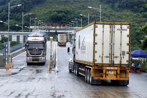 Các xe container chở thanh long xuất khẩu sang Trung Quốc qua cửa khẩu quốc tế đường bộ số II Kim Thành. (Ảnh: Quốc Khánh/TTXVN)