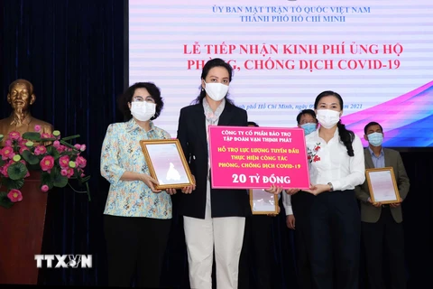  Lãnh đạo Ủy ban Mặt trận Tổ quốc Việt Nam Thành phố tiếp nhận bảng tượng trưng ủng hộ kinh phí phòng, chống COVID-19 và trao thư cảm ơn đến các doanh nghiệp, nhà tài trợ. (Ảnh: Xuân Khu/TTXVN)