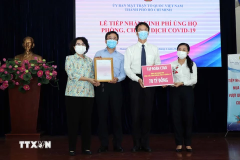 Lãnh đạo Ủy ban Mặt trận Tổ quốc Việt Nam Thành phố tiếp nhận bảng tượng trưng ủng hộ kinh phí phòng, chống COVID-19 và trao thư cảm ơn đến các doanh nghiệp, nhà tài trợ. (Ảnh: Xuân Khu/TTXVN)