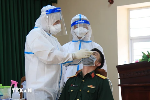 Nhân viên y tế lấy mẫu xét nghiệm sàng lọc virus SARS-CoV-2 cho cán bộ, chiến sỹ các đơn vị lực lượng vũ trang tại Ban chỉ huy quân sự huyện Côn Đảo. (Ảnh: Huỳnh Ngọc Sơn/TTXVN) 