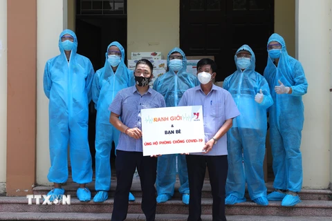 Tình nguyện viên của Chương trình Ranh Giới và bạn bè phối hợp VNews (Truyền hình TTXVN) trao quà hỗ trợ cho Mặt trận Tổ quốc huyện Việt Yên (Bắc Giang). (Ảnh: Danh Lam/TTXVN)