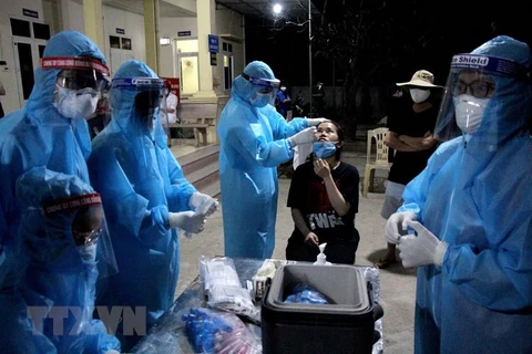 Lực lượng y bác sỹ xuyên đêm lấy mẫu xét nghiệm đối với các trường hợp là F1 của bệnh nhân số 11634 ở huyện Diễn Châu, Nghệ An. (Ảnh: Văn Tý/TTXVN) 
