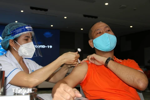 Các y, bác sỹ thực hiện tiêm chủng vaccine phòng COVID-19 cho nhân viên, người lao động Công ty trách nhiệm hữu hạn phần mềm FPT ở Khu công nghệ cao Thành phố Hồ Chí Minh. (Ảnh: Thanh Vũ/TTXVN) 