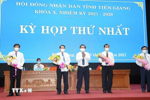 Chủ tịch Hội đồng nhân dân tỉnh Tiền Giang khóa X, nhiệm kỳ 2021-2026 Võ Văn Bình tặng hoa chúc mừng lãnh đạo Ủy ban nhân dân tỉnh Tiền Giang tiếp tục trúng cử. (Ảnh: Hữu Chí/TTXVN)