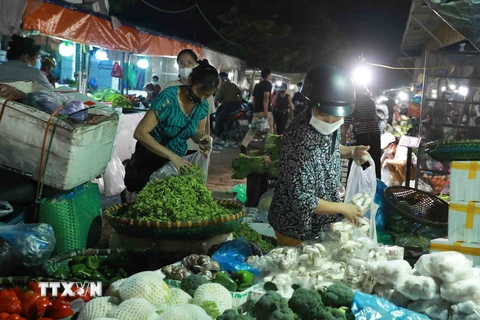 Người dân lựa chọn mua rau củ tại chợ đầu mối Minh Khai. (Ảnh: Vũ Sinh/TTXVN) 