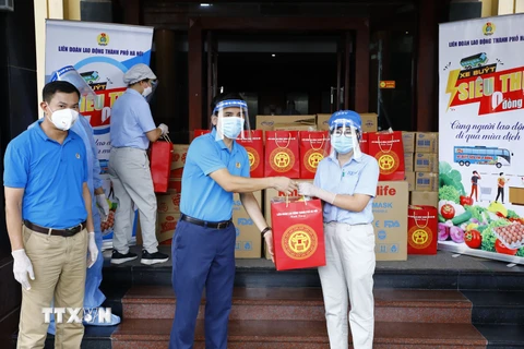 Phó Chủ tịch Liên đoàn Lao động thành phố Hà Nội Lê Đình Hùng trao quà cho công nhân đang cách ly tại khách sạn Hà Anh. (Ảnh: Minh Đức/TTXVN) 