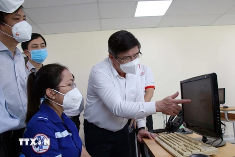 Chủ tịch UBND Thành phố Hồ Chí Minh Nguyễn Thành Phong trao đổi về việc điều phối vận chuyển cấp cứu đến các bệnh viện. (Ảnh: Tiến Lực/TTXVN)